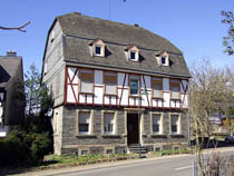 дом с полувальмовой крышей и отделкой в стиле фахверк